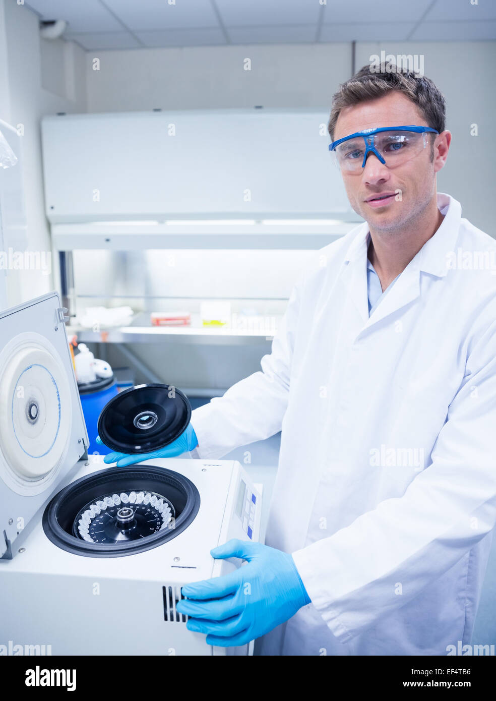 Chemist wearing safety glasses and using a centrifuge Stock Photo