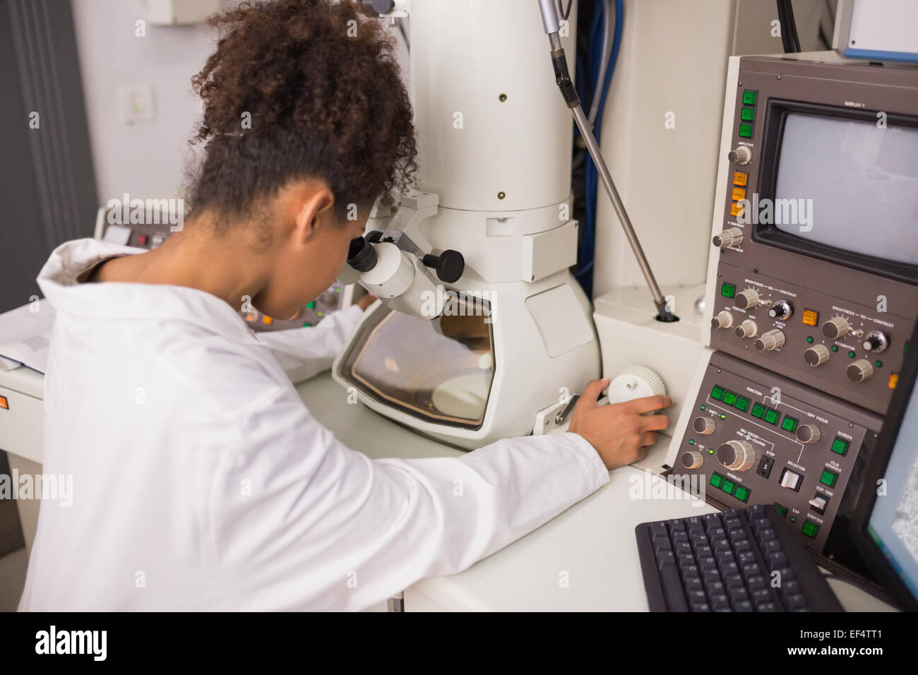 Biochemistry student using large microscope and computer Stock Photo