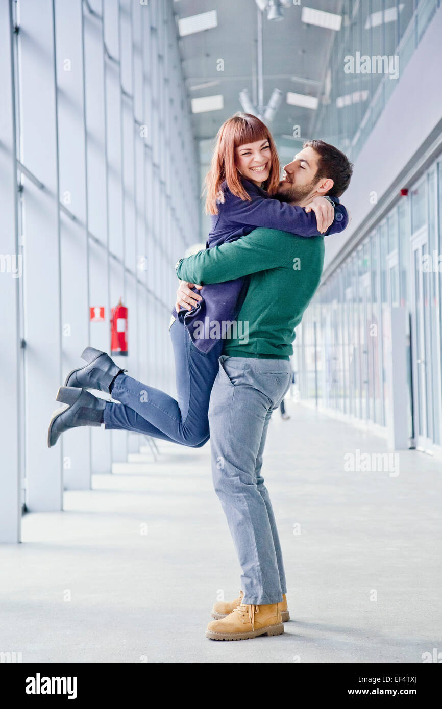 Young couple embracing in airport building Stock Photo