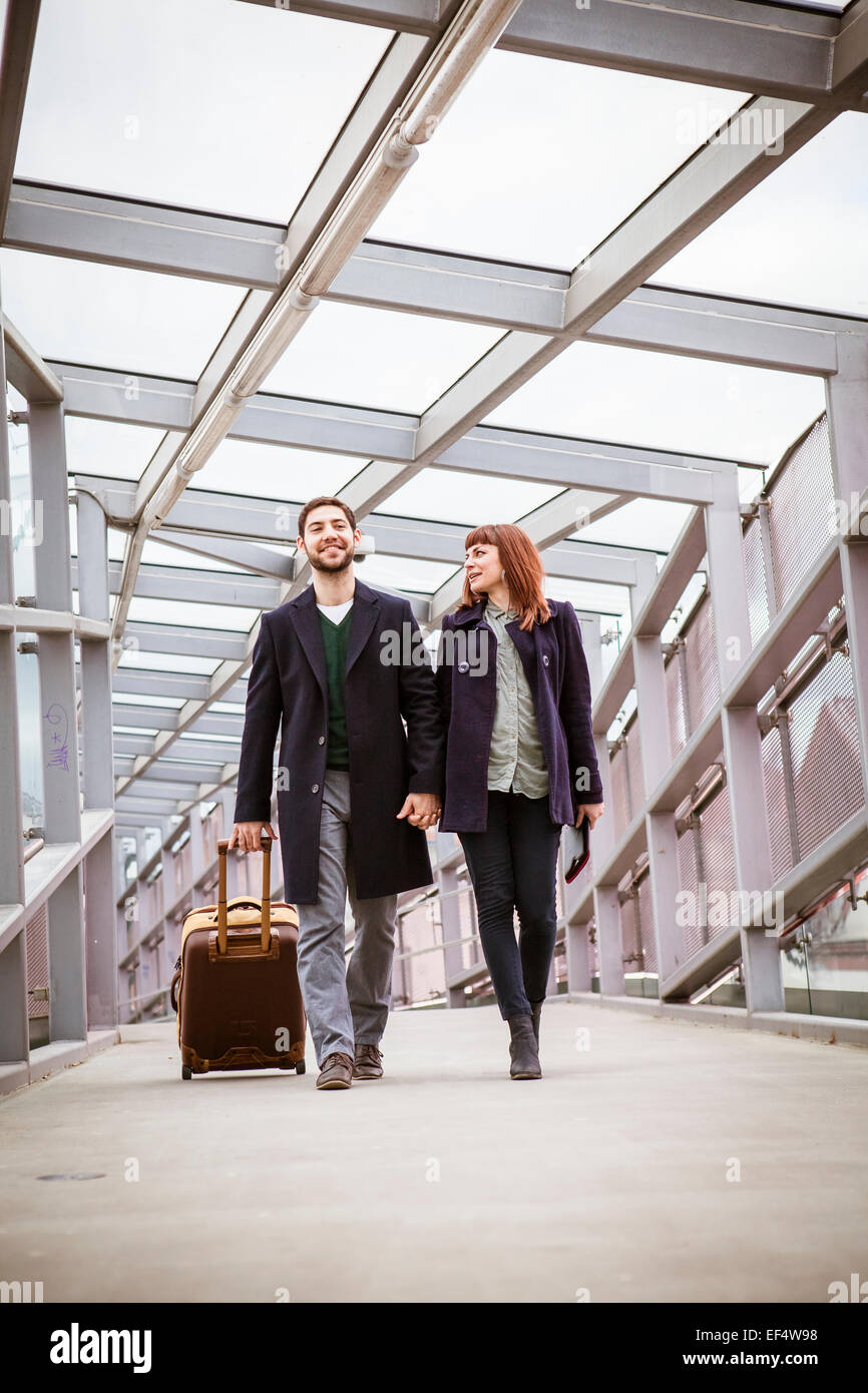 Young couple in airport building holding hands Stock Photo - Alamy