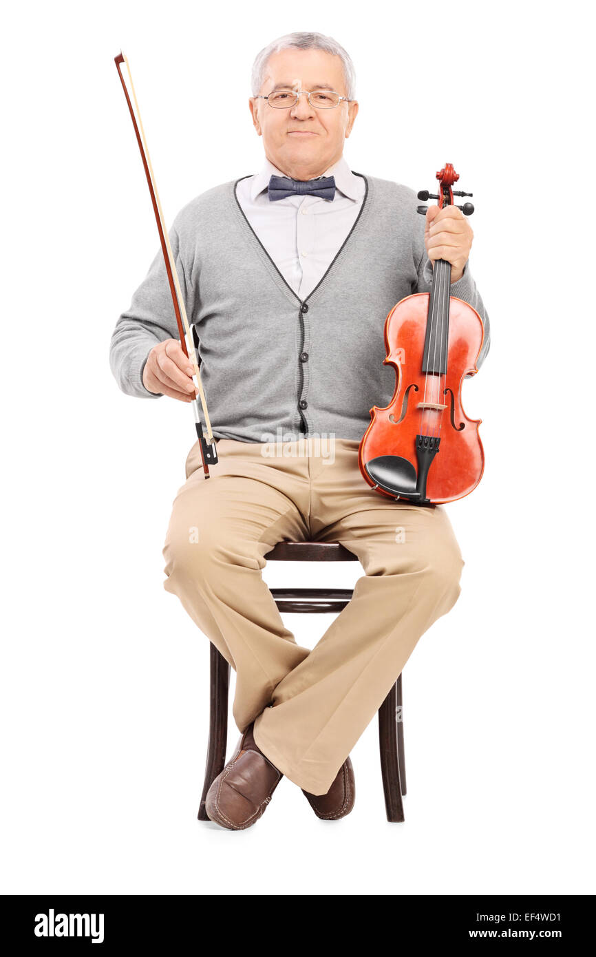 Senior sitting on a chair and holding a violin isolated on white ...