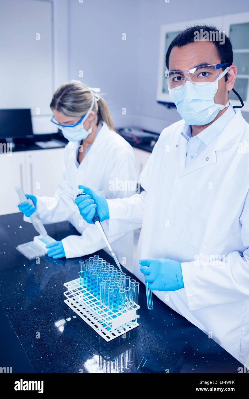 Science students using pipettes to fill test tubes Stock Photo