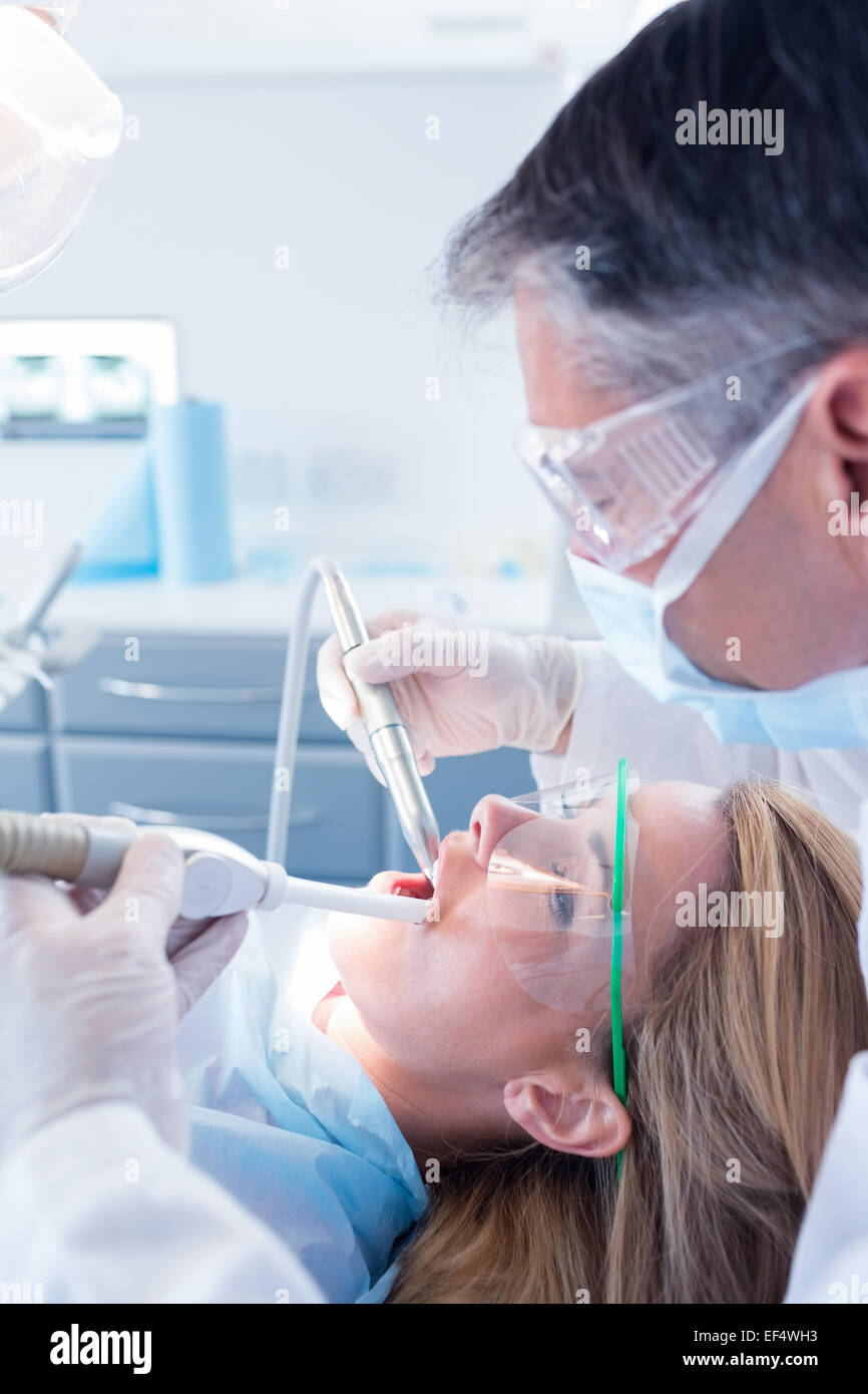 Dentist examining his patient with a suction hose Stock Photo Alamy