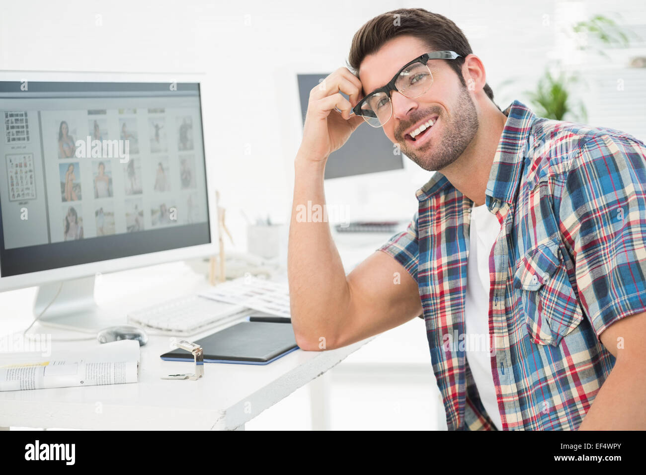 Smiling casual businessman sitting at desk Stock Photo - Alamy