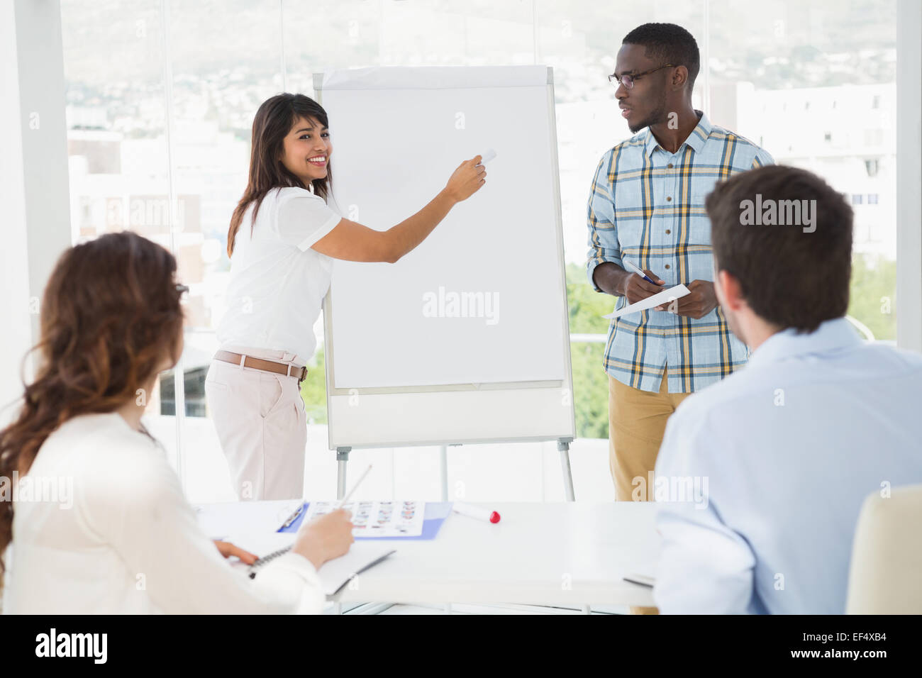 Smiling woman presenting and writing on whiteboard Stock Photo - Alamy