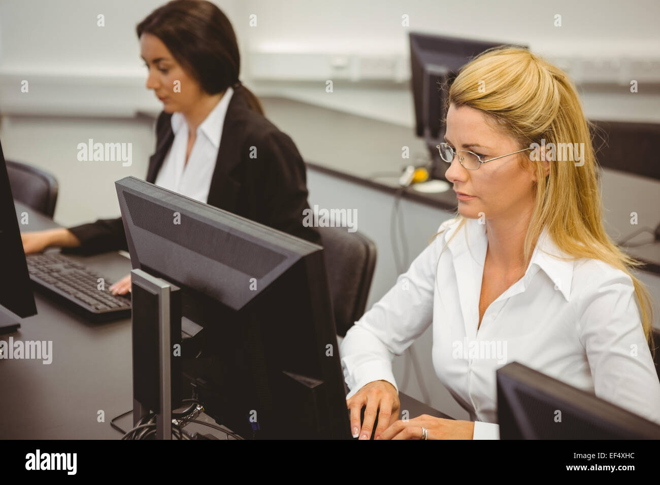 Focused businesswomen working in computer room Stock Photo - Alamy