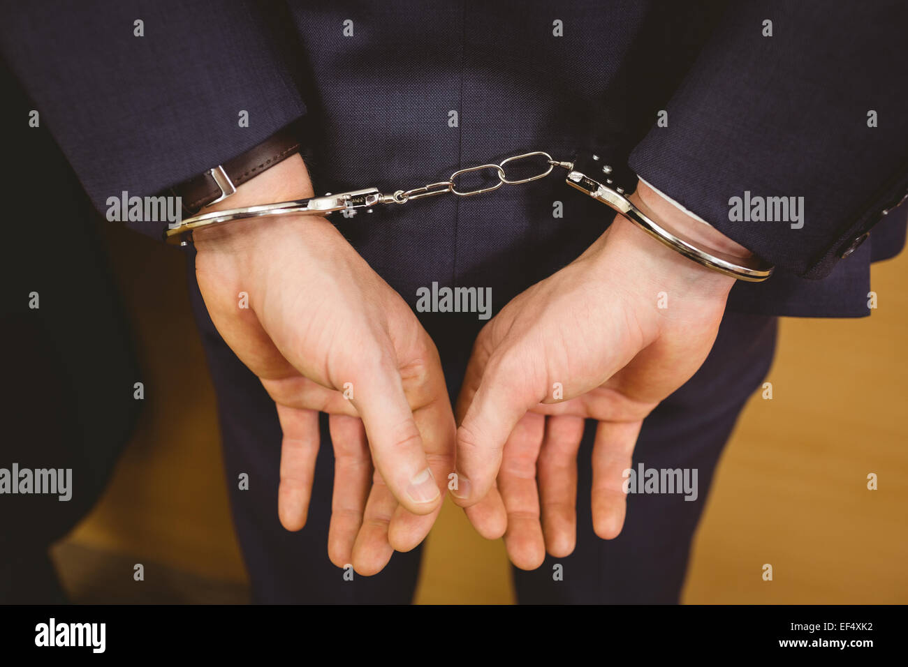 Hands of businessman with handcuffs Stock Photo