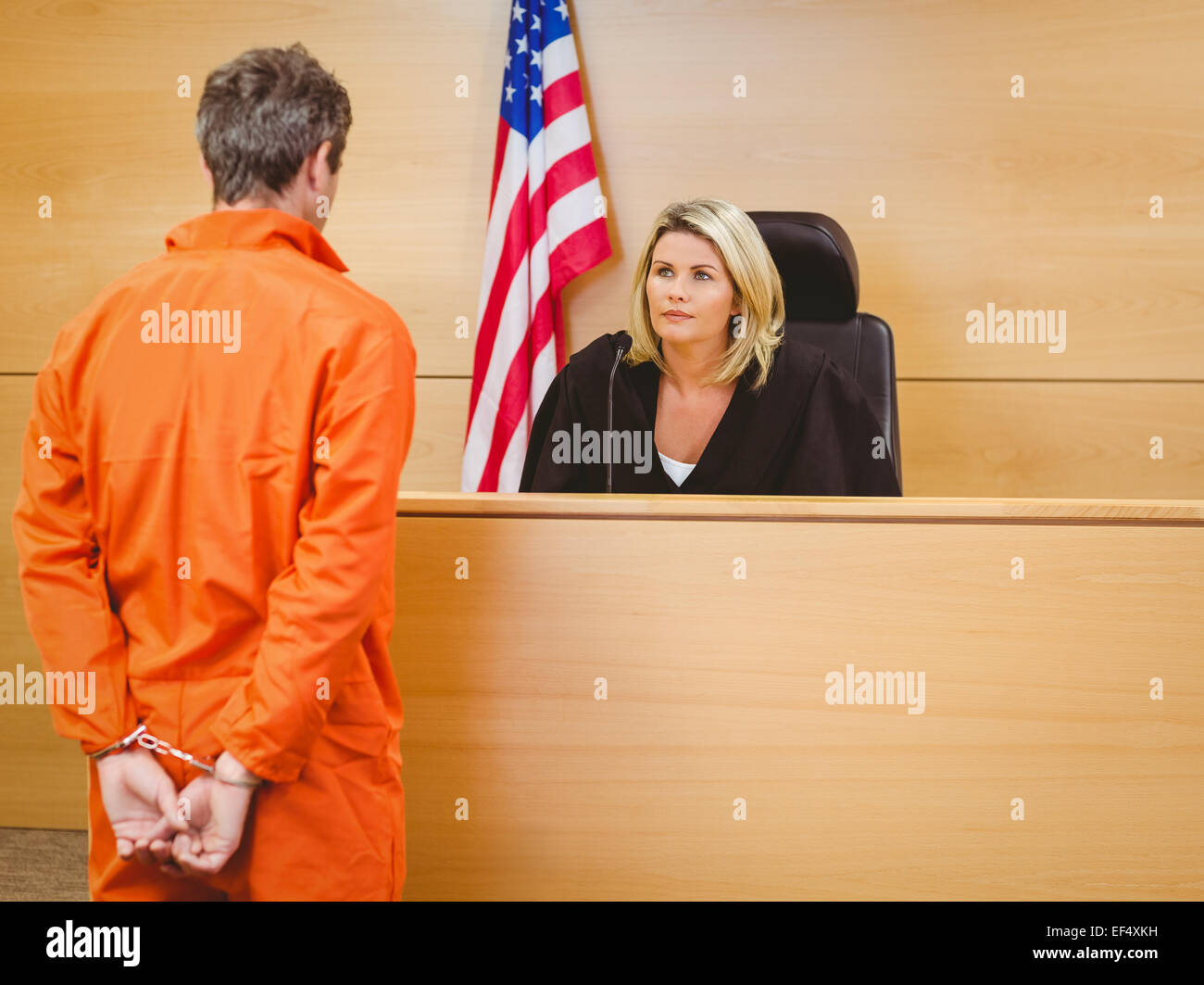 Judge and criminal speaking in front of the american flag Stock Photo