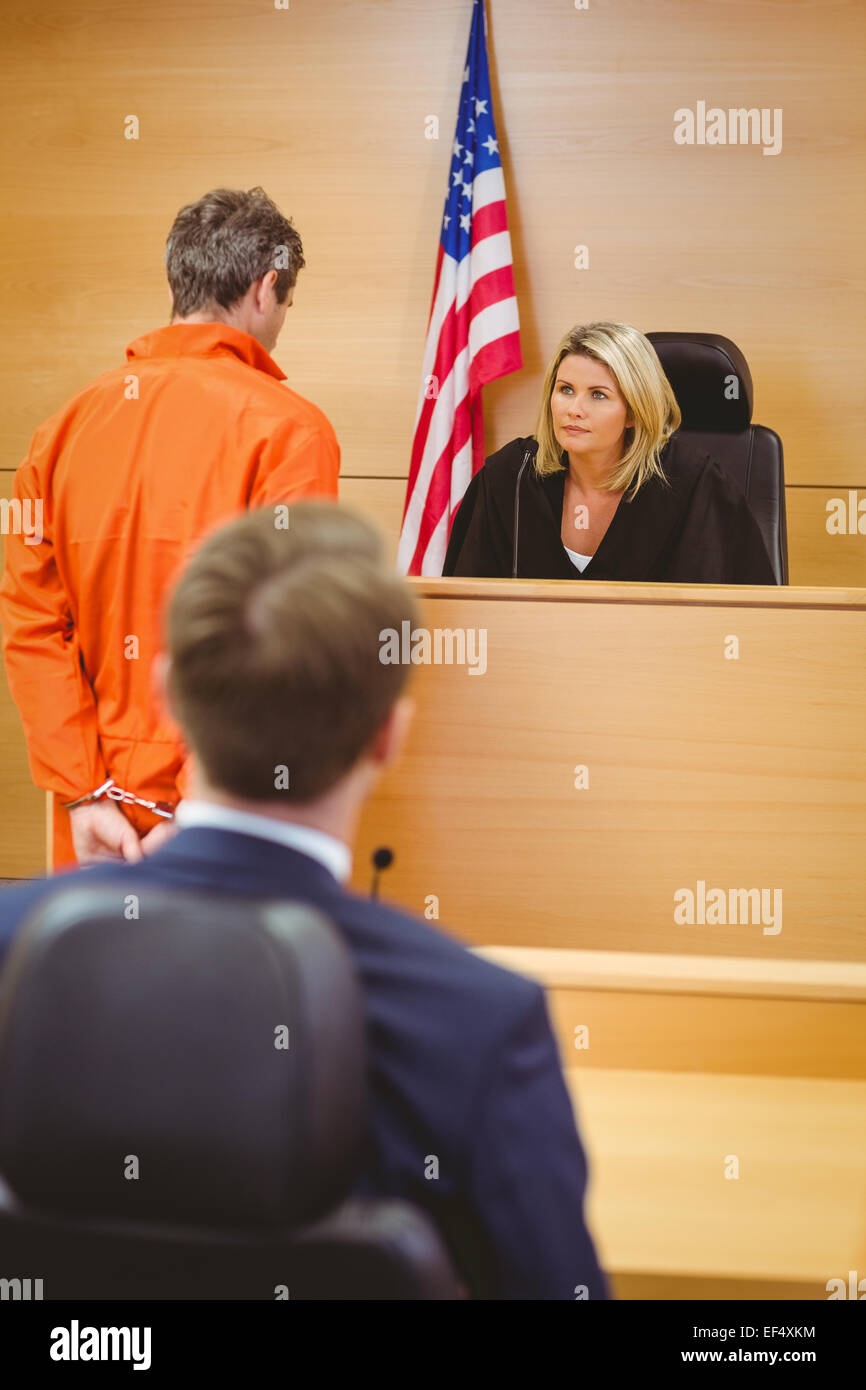 Judge and criminal speaking in front of the american flag Stock Photo