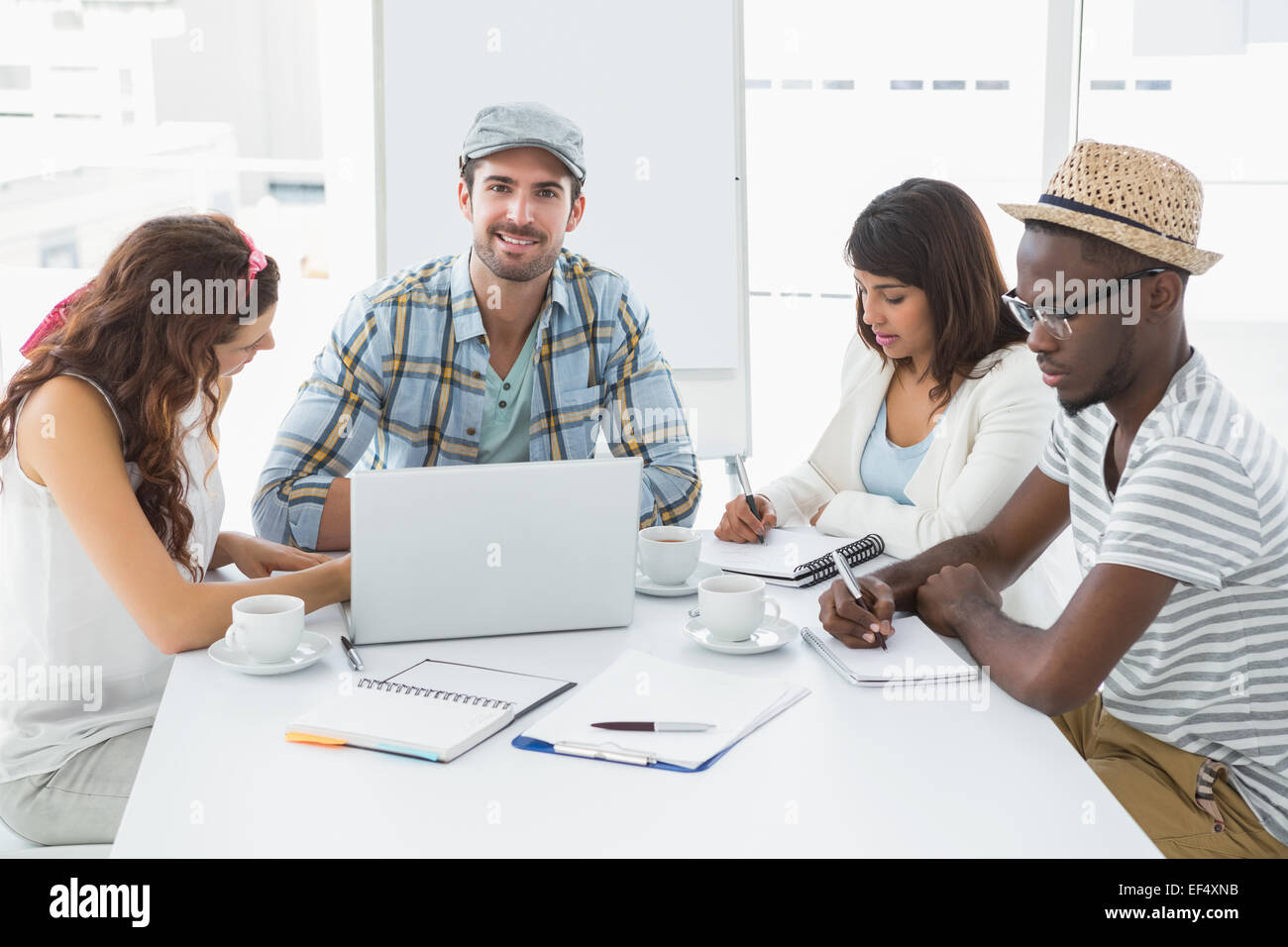 Colleagues taking notes and using laptop Stock Photo - Alamy