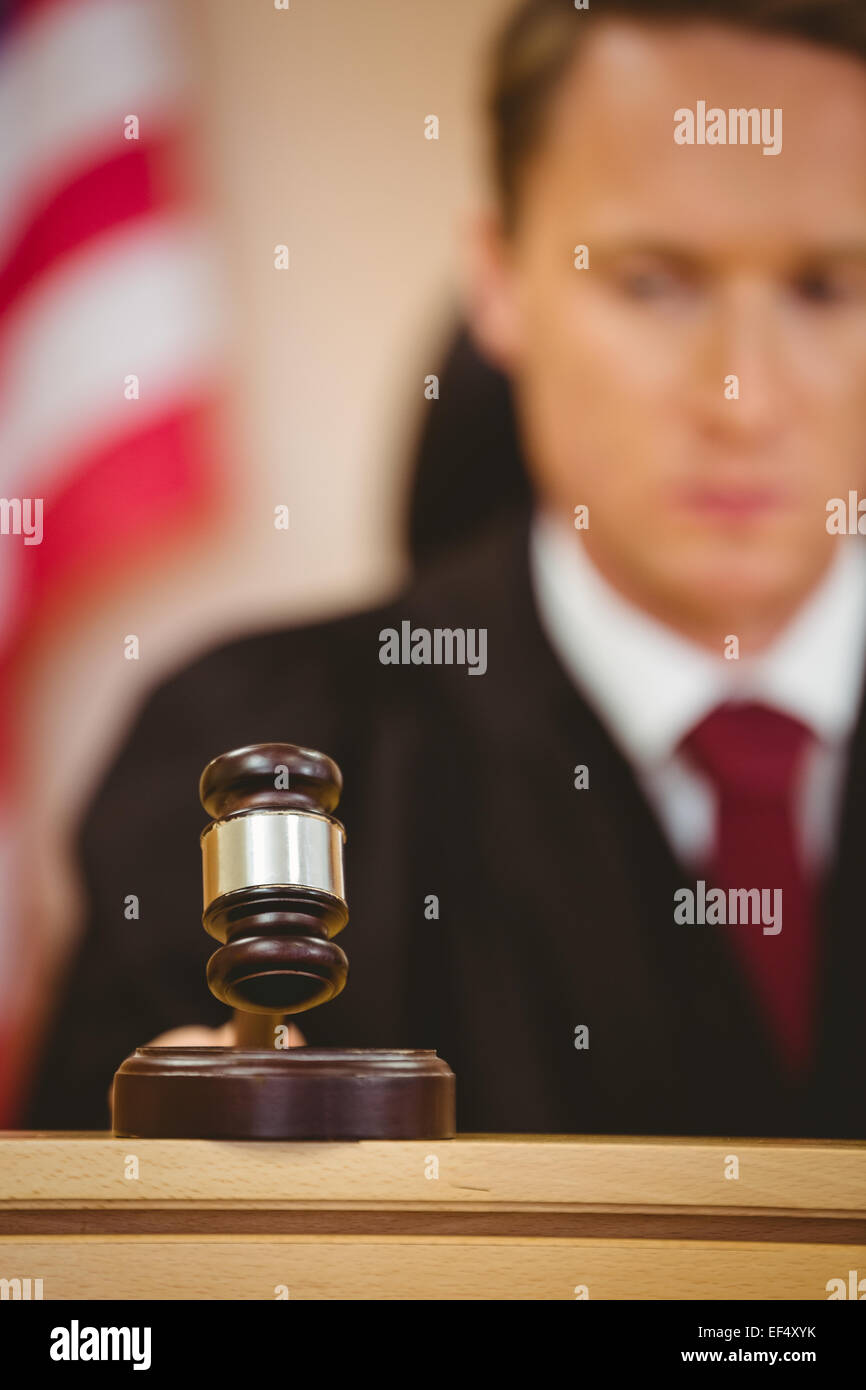 Serious judge about to bang gavel on sounding block Stock Photo Alamy