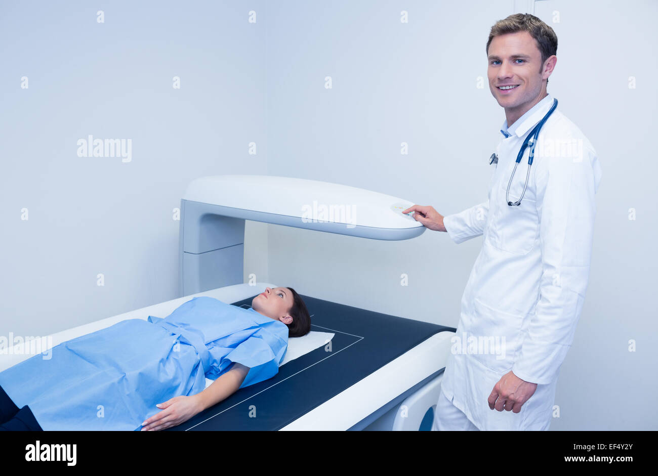 Smiling doctor doing a radiography on a patient Stock Photo - Alamy