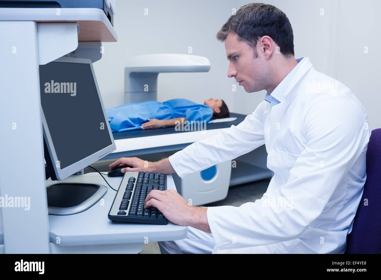 Doctor looking his computer while proceeding a radiography Stock Photo