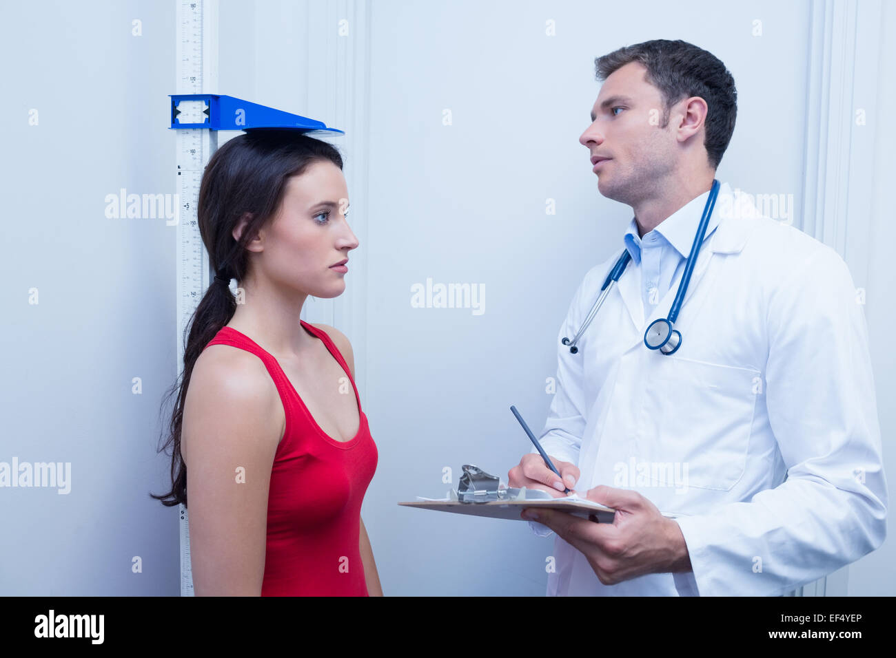 Confident doctor measuring patients height Stock Photo