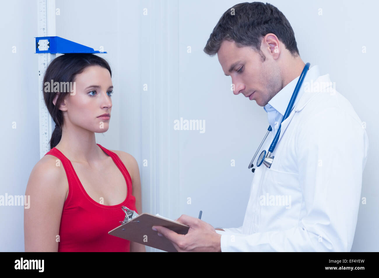 Doctor writing size of his patient on clipboard Stock Photo