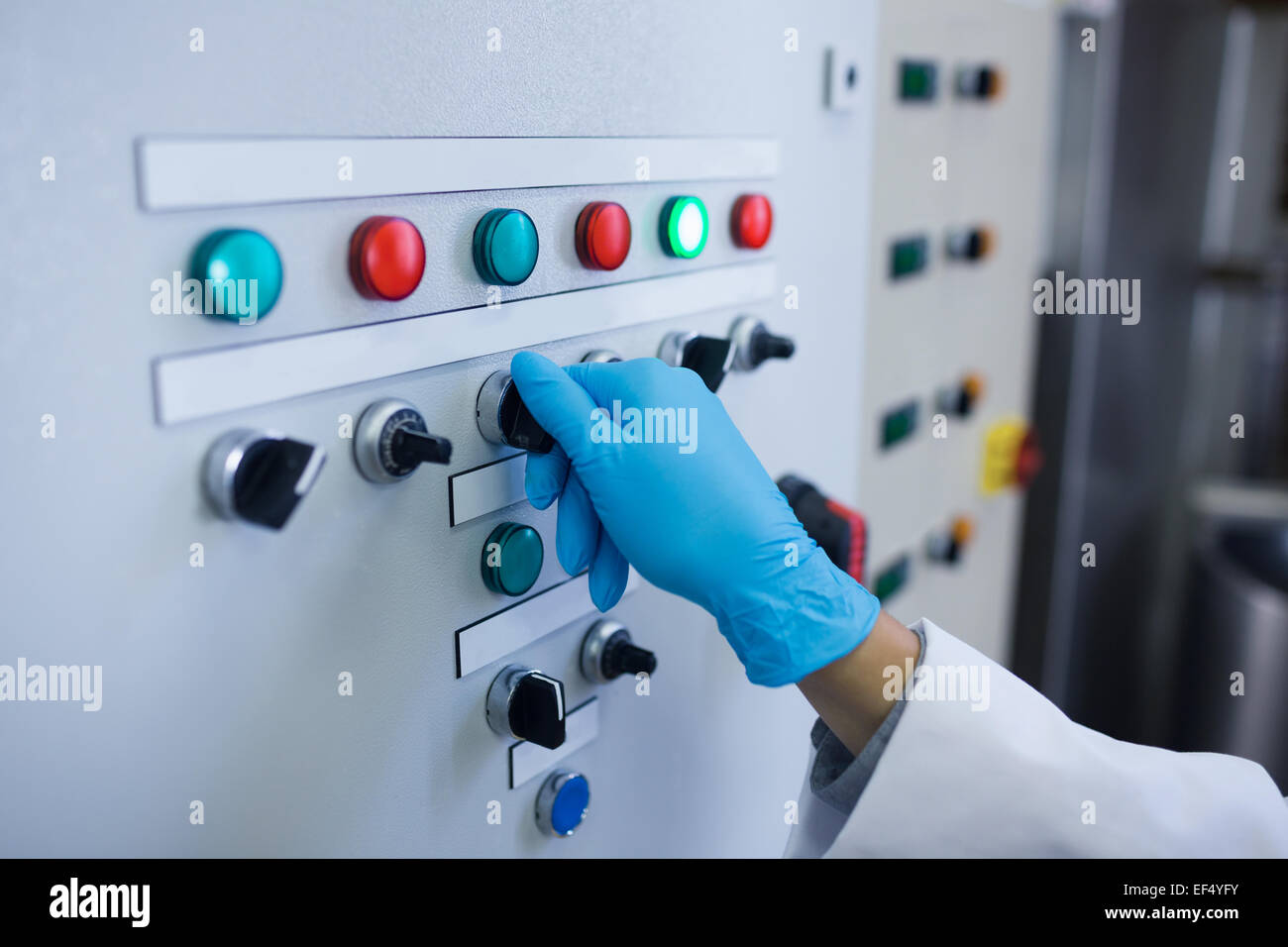 Hand with gloves turning buttons of the machine Stock Photo