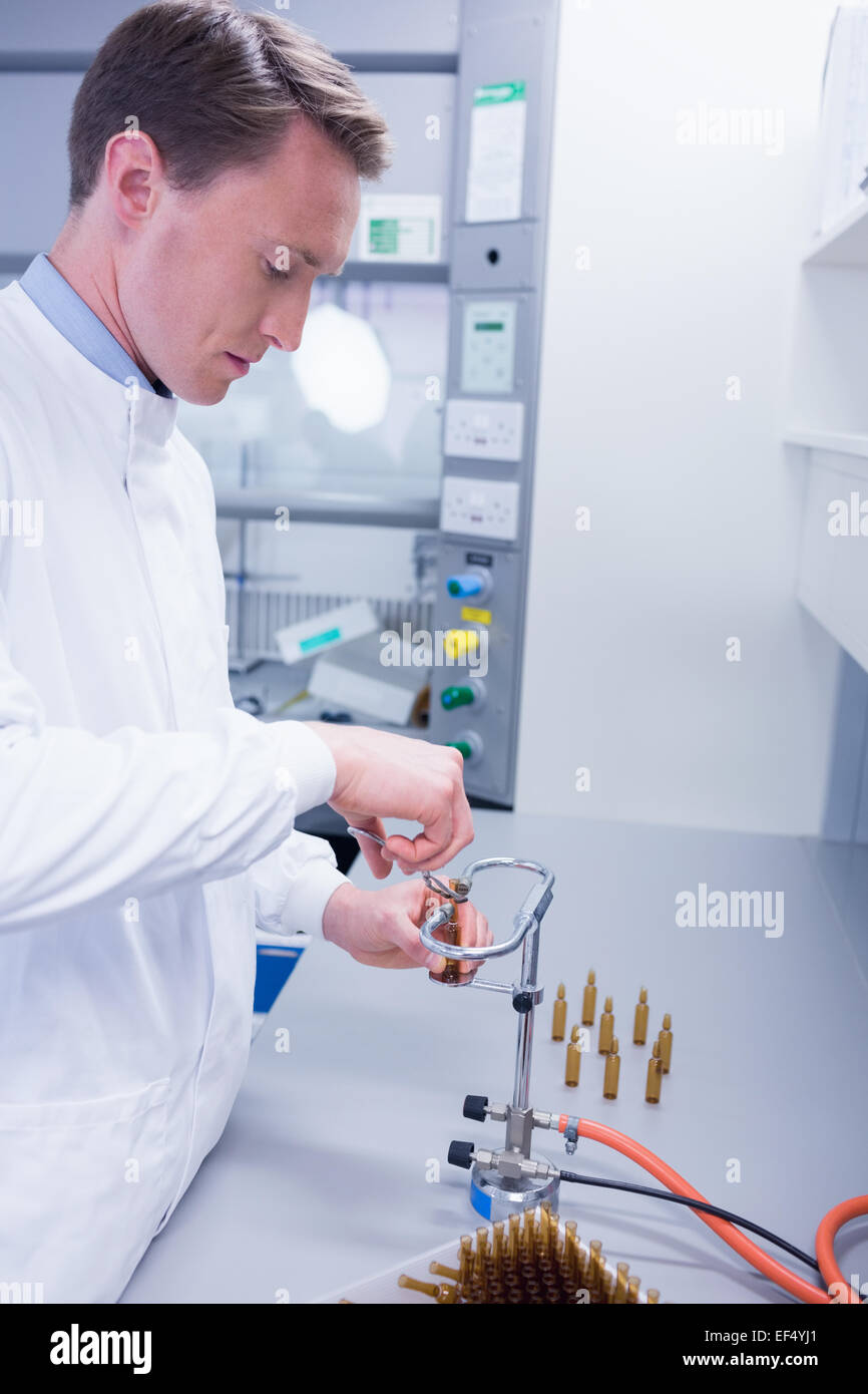 Focused biochemist sealing a vial Stock Photo
