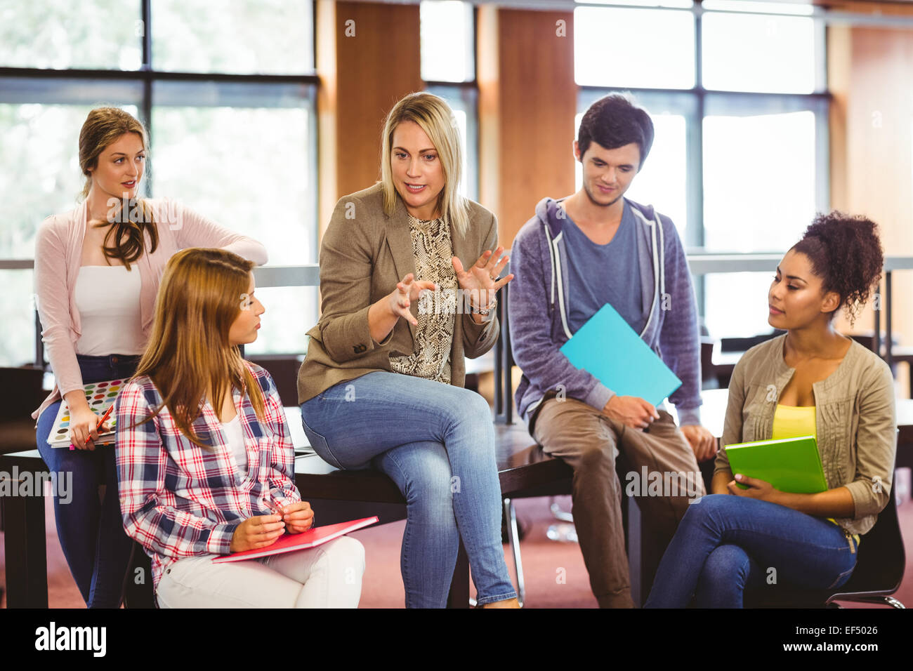 Happy students talking with their teacher Stock Photo - Alamy