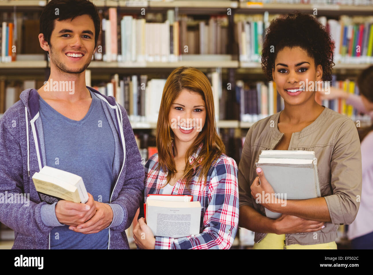 Students standing and smiling at camera holding books Stock Photo - Alamy