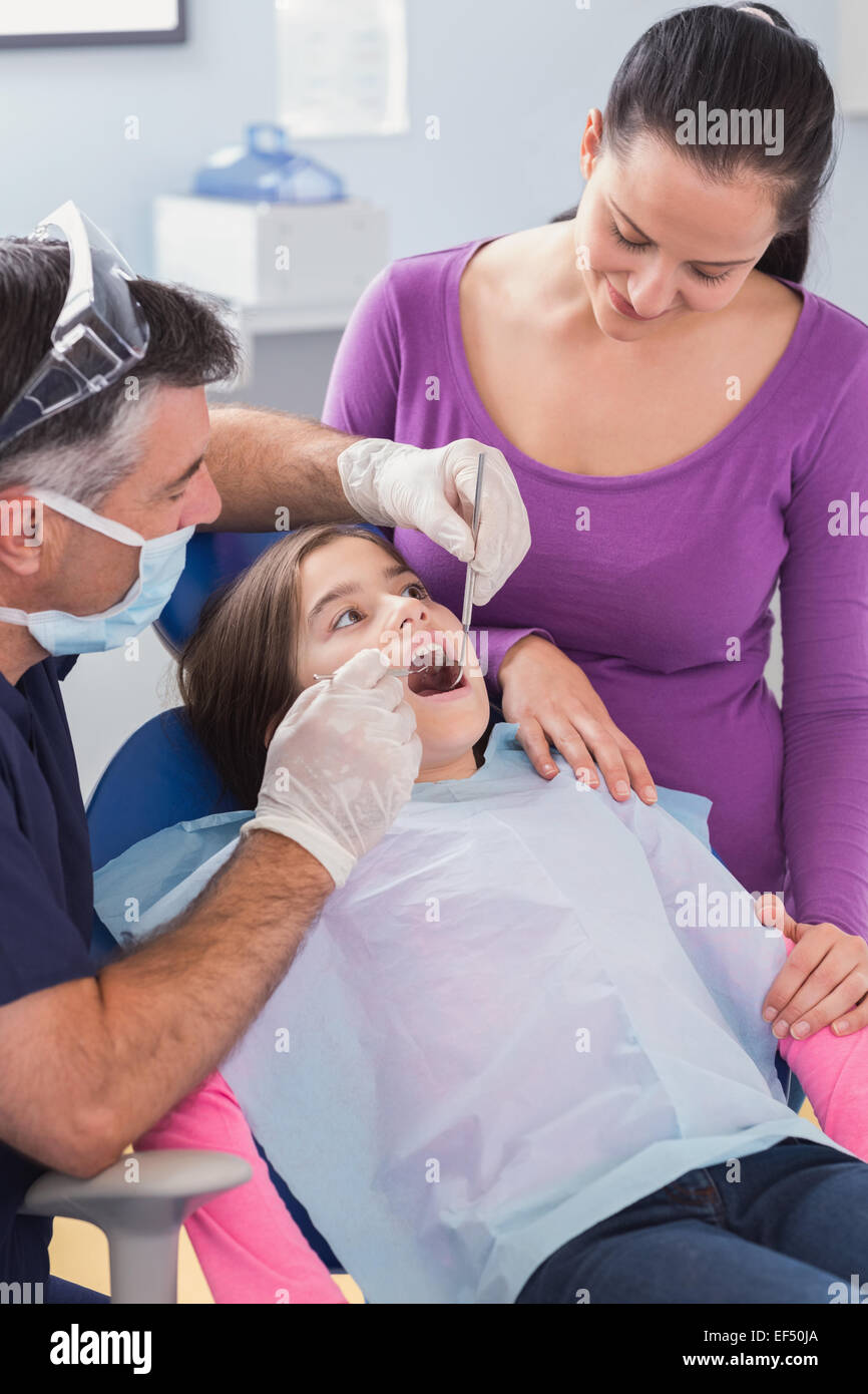 Pediatric dentist examining young patient with her mother Stock Photo