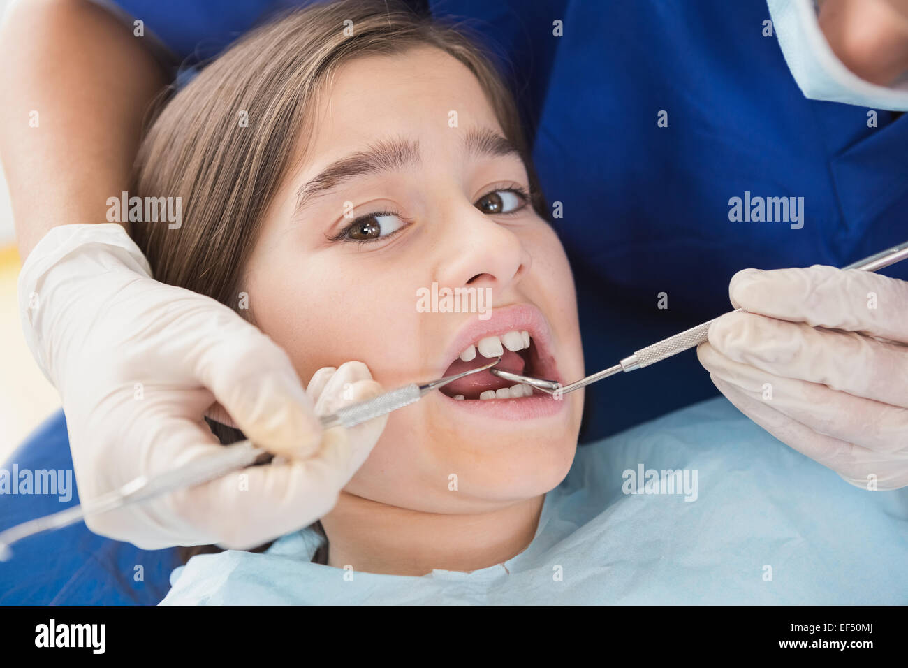 Pediatric dentist using dental explorer and angled mirror Stock Photo Alamy