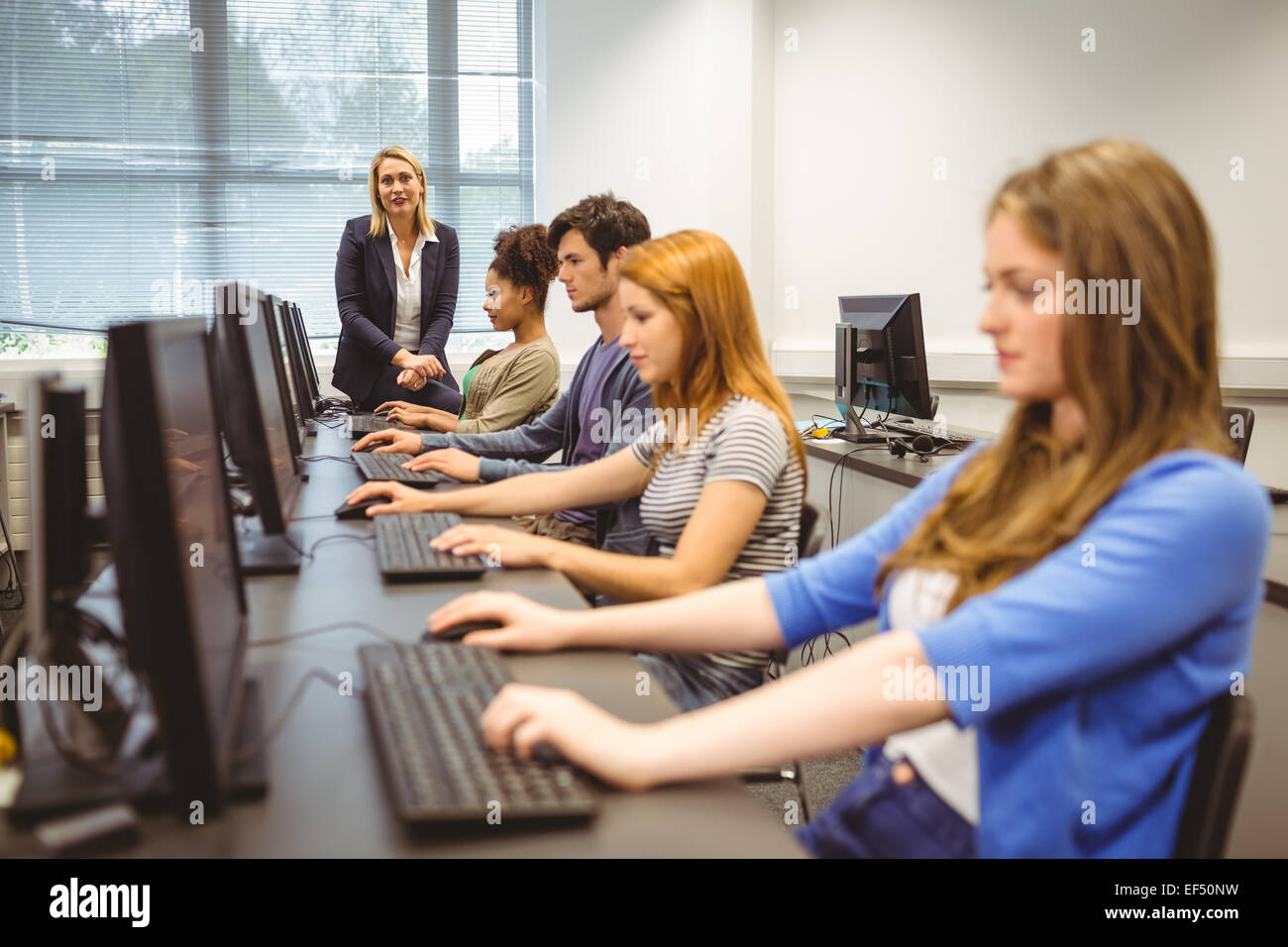 Four focused students with teacher at the end of the class Stock Photo