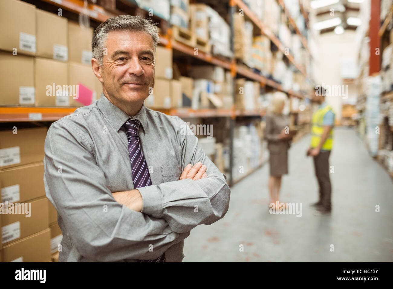 Smiling businessman with crossed arms Stock Photo - Alamy