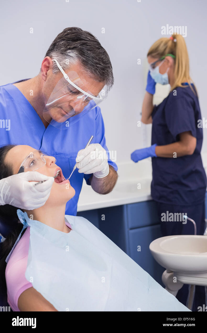 Dentist wearing face shield and examining a patient Stock Photo Alamy