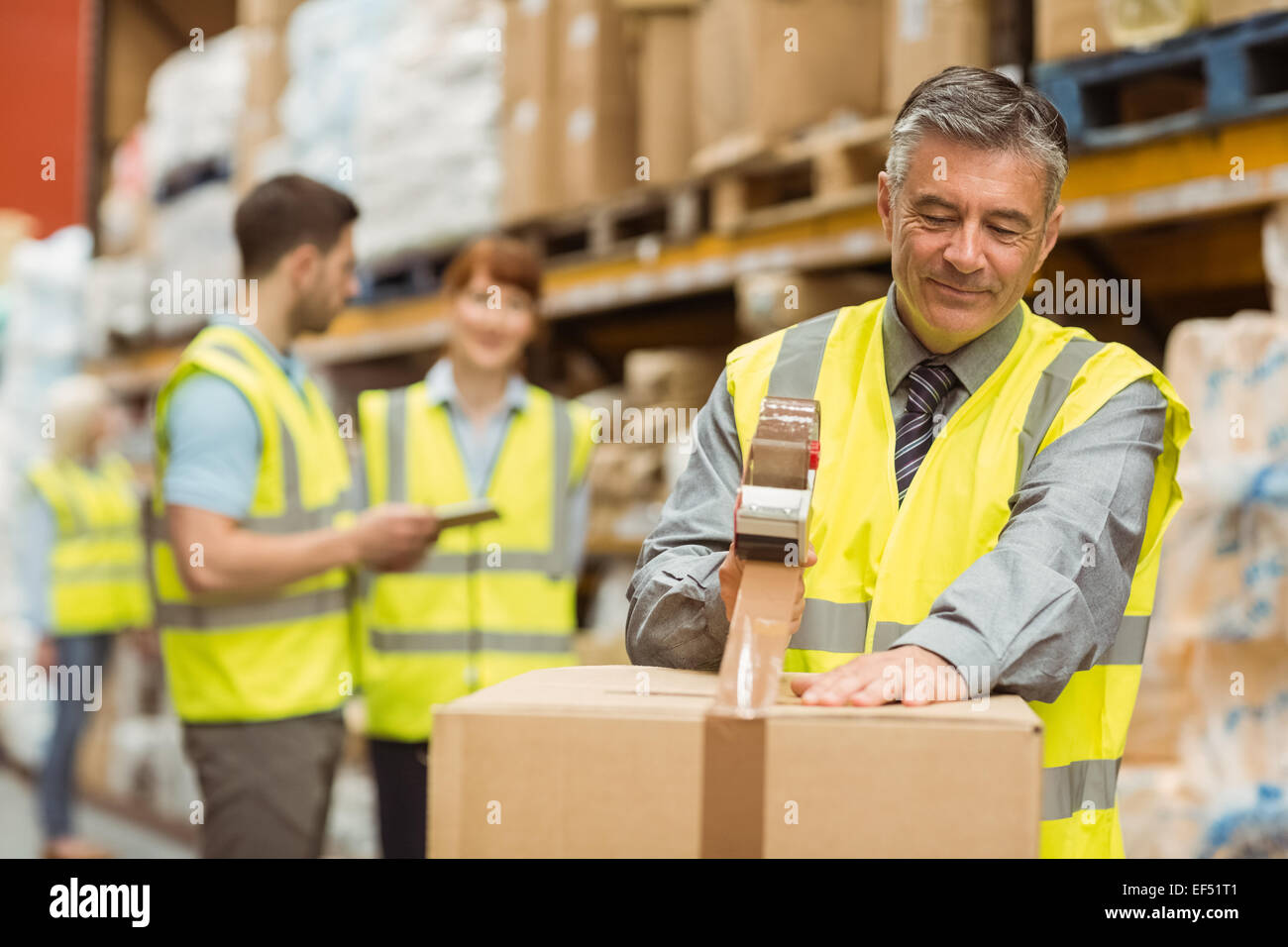 Warehouse worker sealing cardboard boxes for shipping Stock Photo Alamy