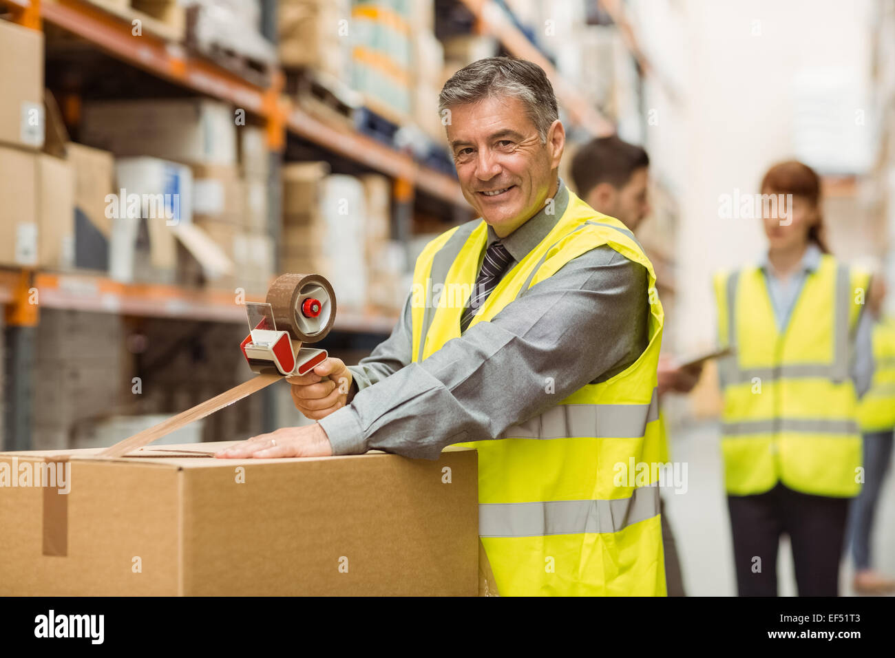 Warehouse worker sealing cardboard boxes for shipping Stock Photo Alamy