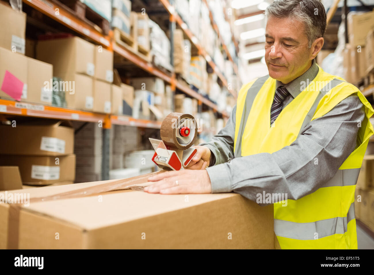 Warehouse worker sealing cardboard boxes for shipping Stock Photo Alamy