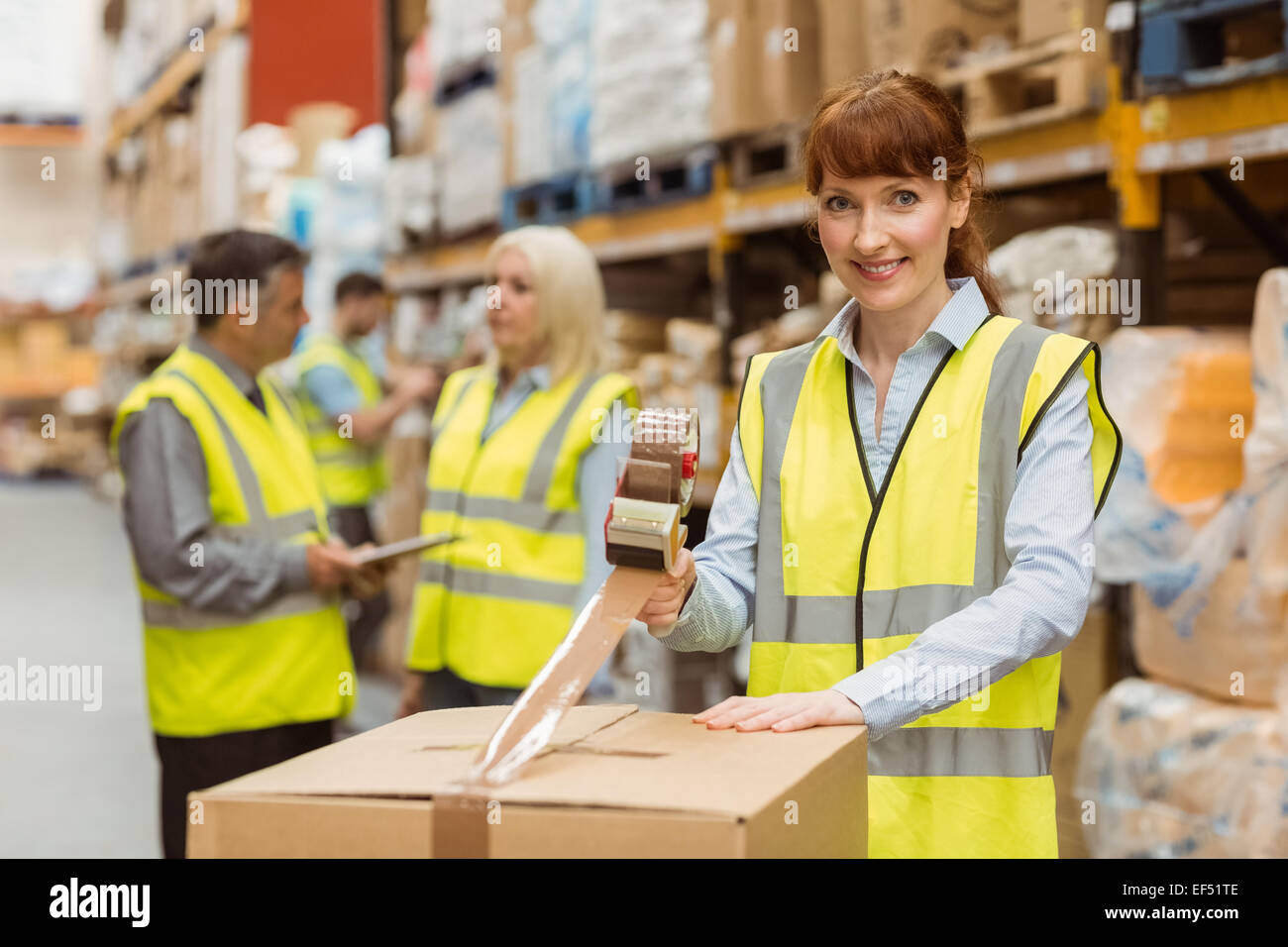 Smiling warehouse workers preparing a shipment Stock Photo - Alamy