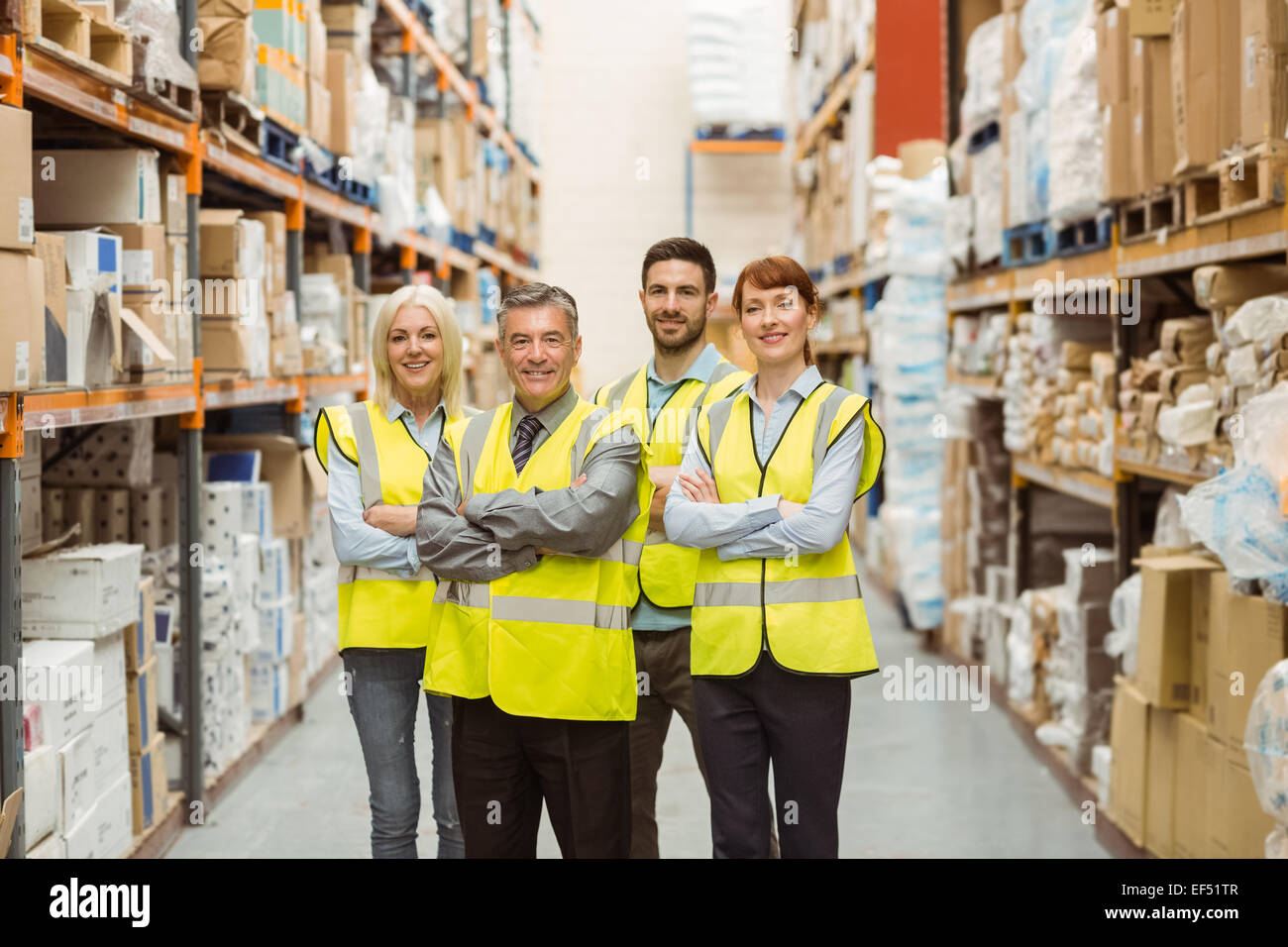Smiling warehouse team with arms crossed Stock Photo - Alamy