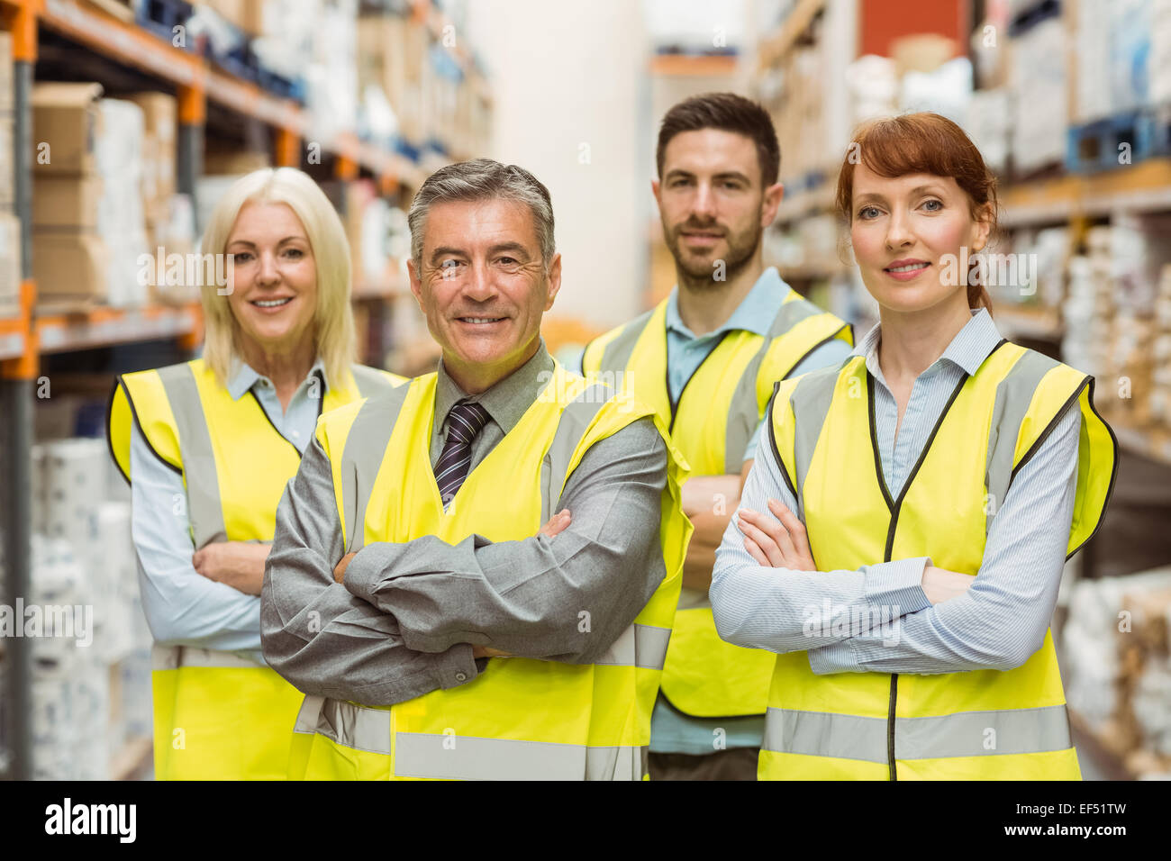 Smiling warehouse team with arms crossed Stock Photo - Alamy