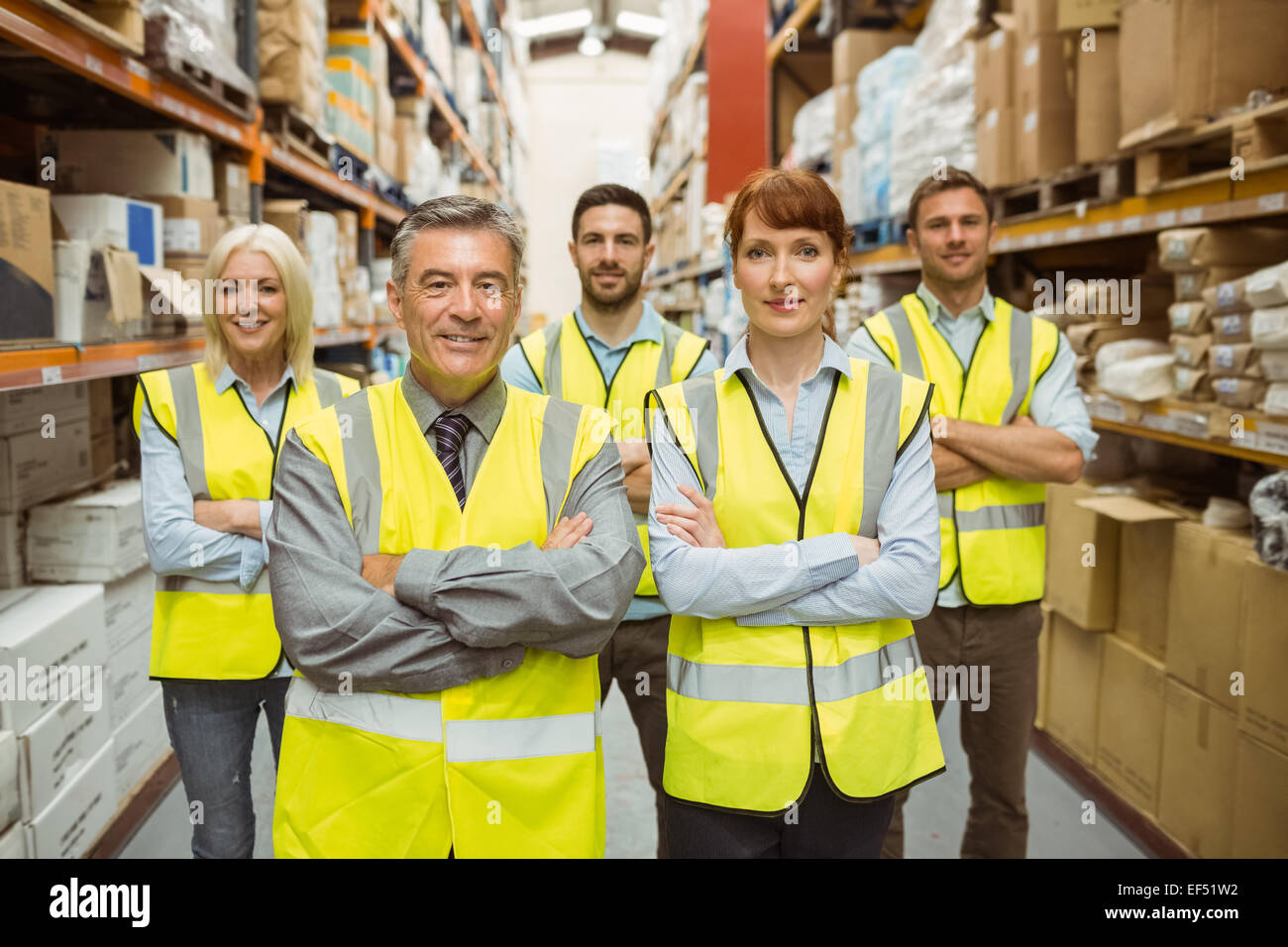 Smiling warehouse team with arms crossed Stock Photo - Alamy