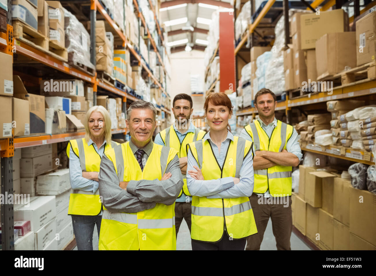 Smiling warehouse team with arms crossed Stock Photo - Alamy