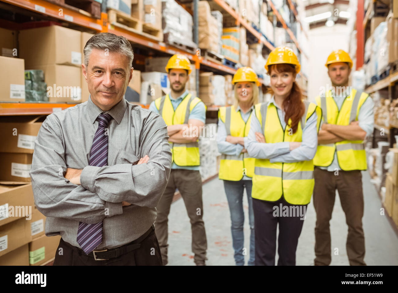 Smiling warehouse team with arms crossed Stock Photo - Alamy