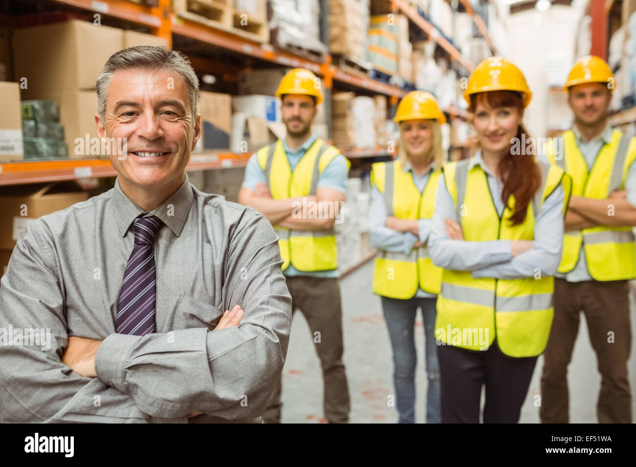 Smiling warehouse team with arms crossed Stock Photo - Alamy