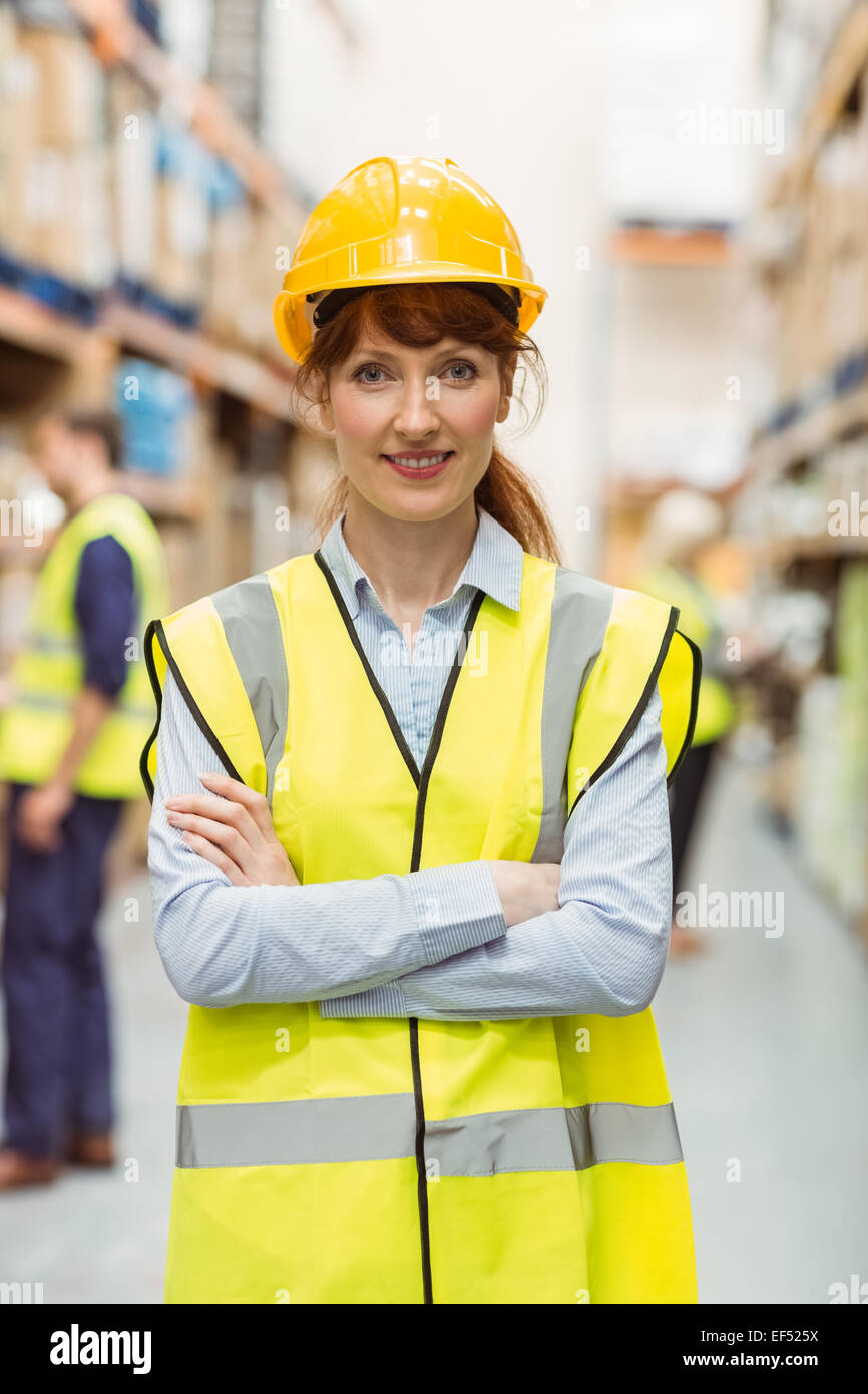 Warehouse manager smiling at camera with arms crossed Stock Photo - Alamy