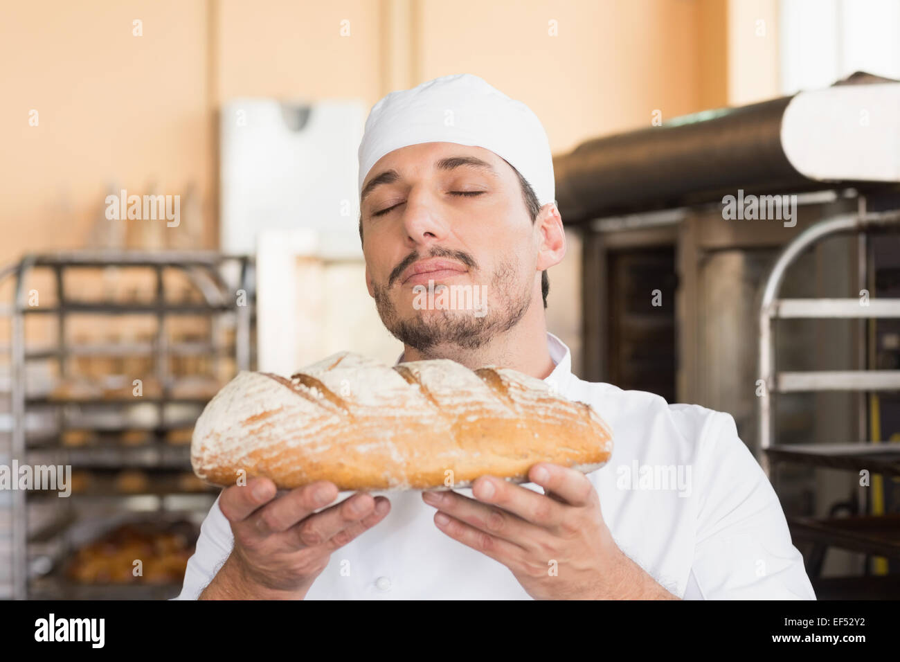 Baker smelling freshly baked loaf Stock Photo