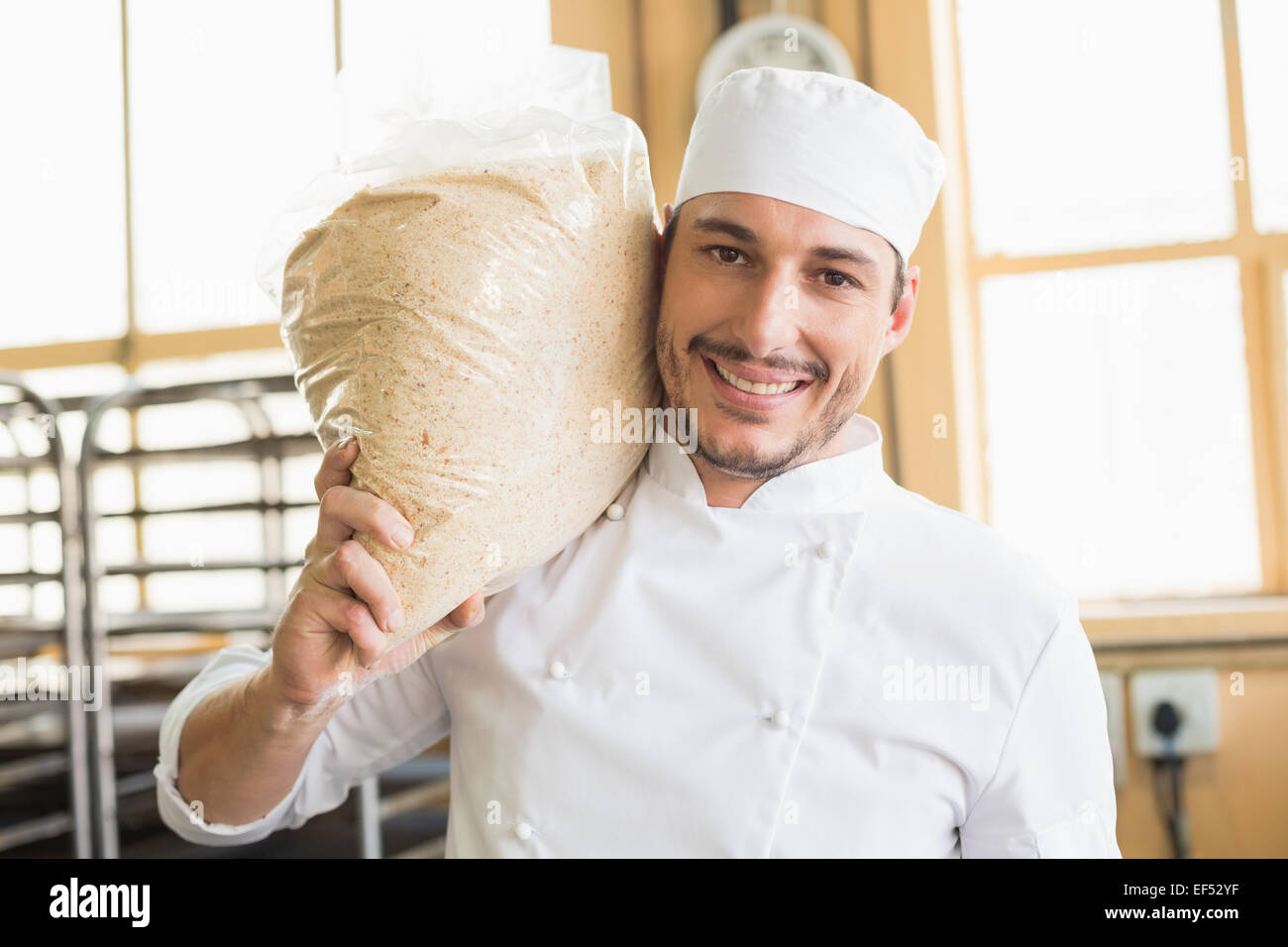 Smiling baker holding bag of rising dough Stock Photo