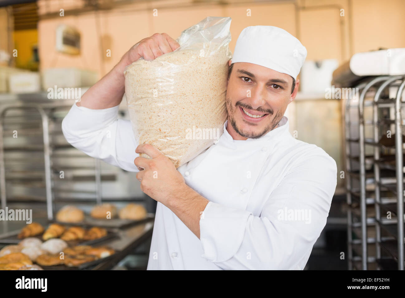 Smiling baker holding bag of rising dough Stock Photo