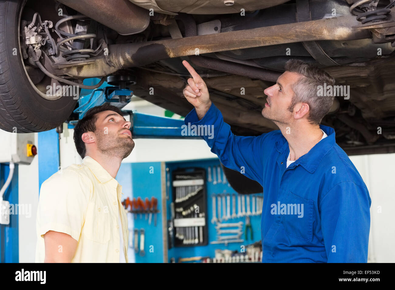Mechanic showing customer the problem with car Stock Photo Alamy