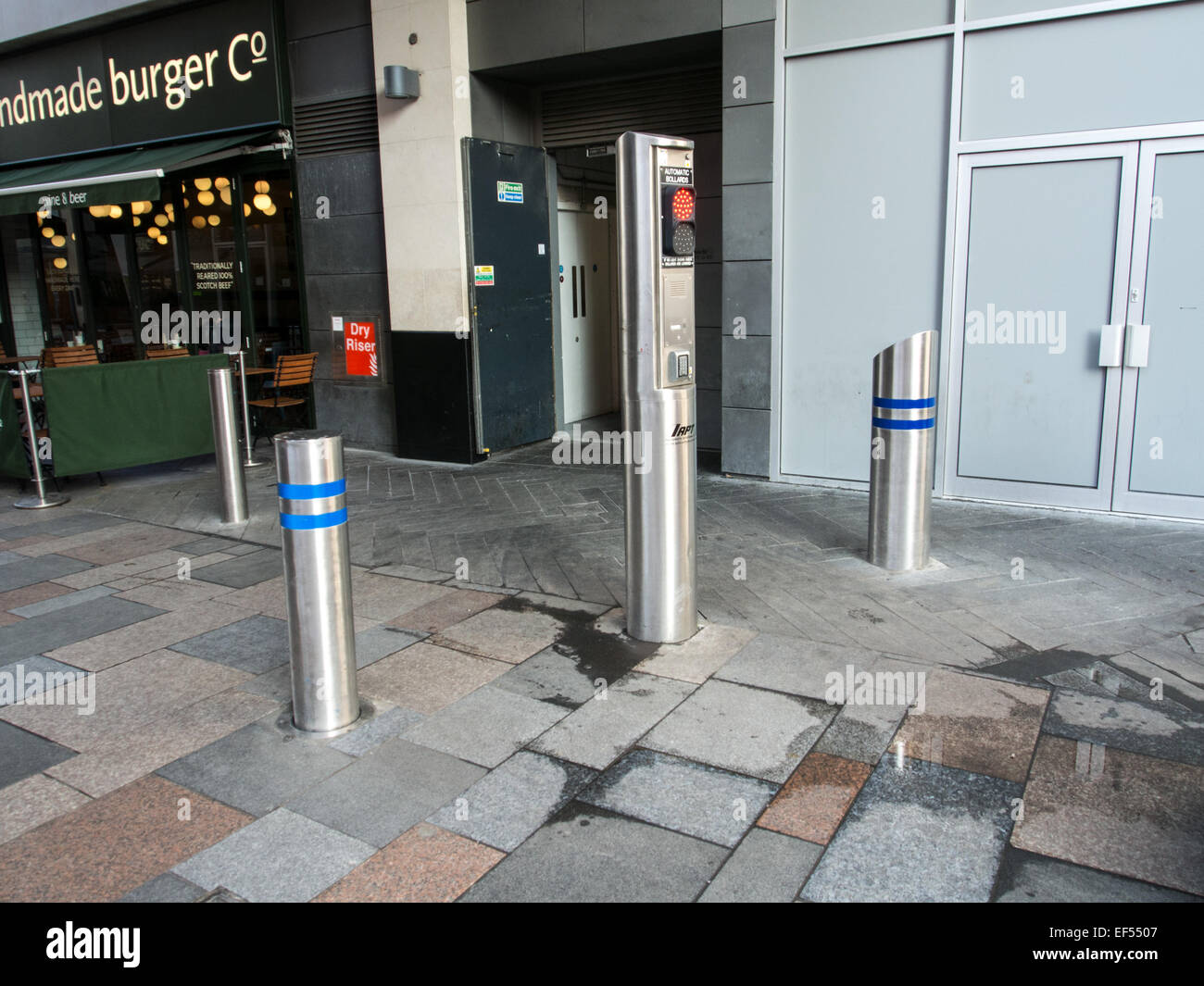 Automatic street security bollards of polished steel with traffic