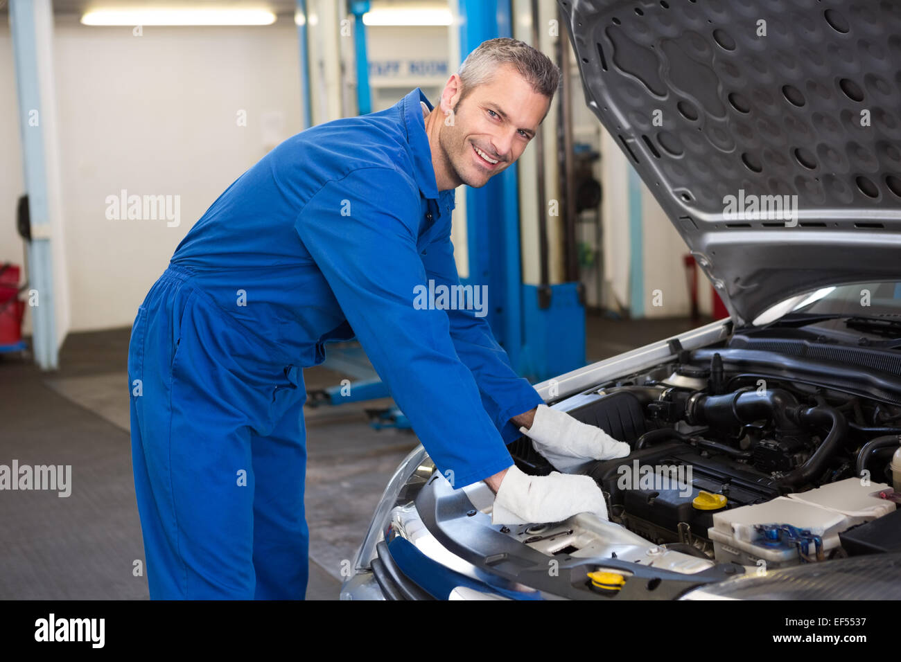 Mechanic examining under hood of car Stock Photo Alamy