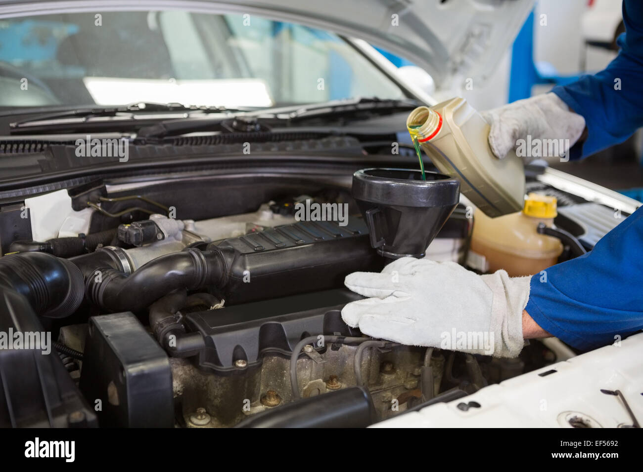 Mechanic pouring oil into car Stock Photo Alamy