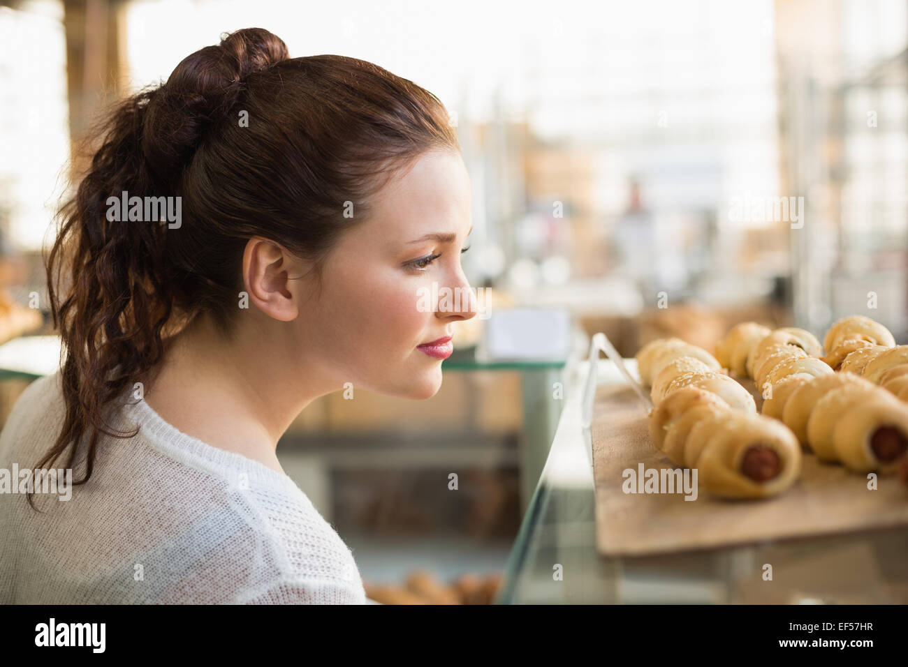 Woman eyeing up tray of pastrys Stock Photo
