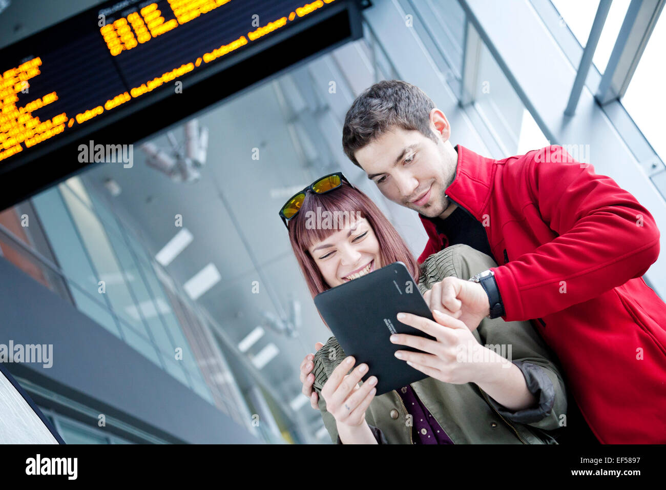 Young couple in airport building using digital tablet Stock Photo