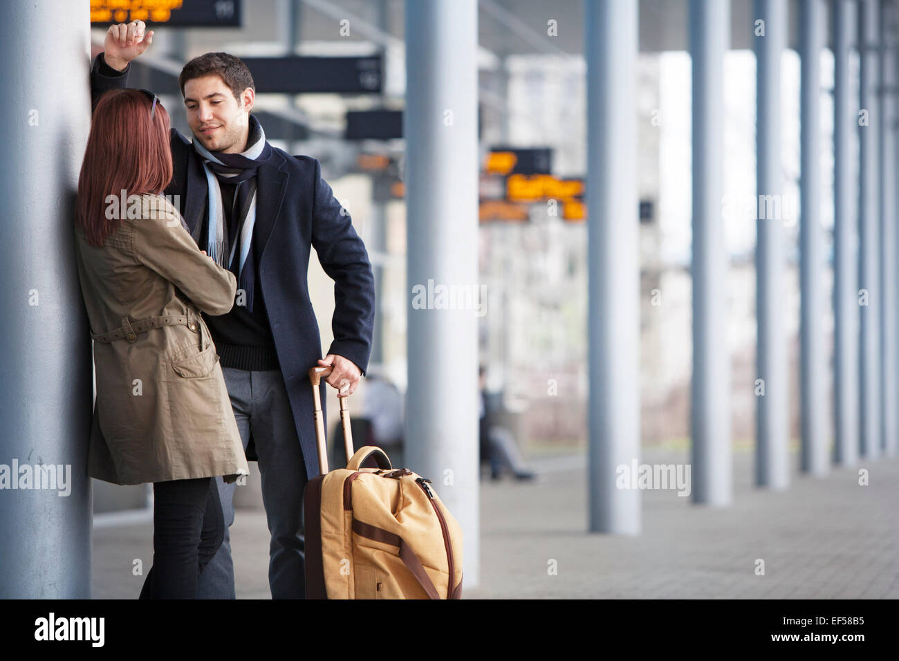 Young couple with luggage by airport building Stock Photo Alamy
