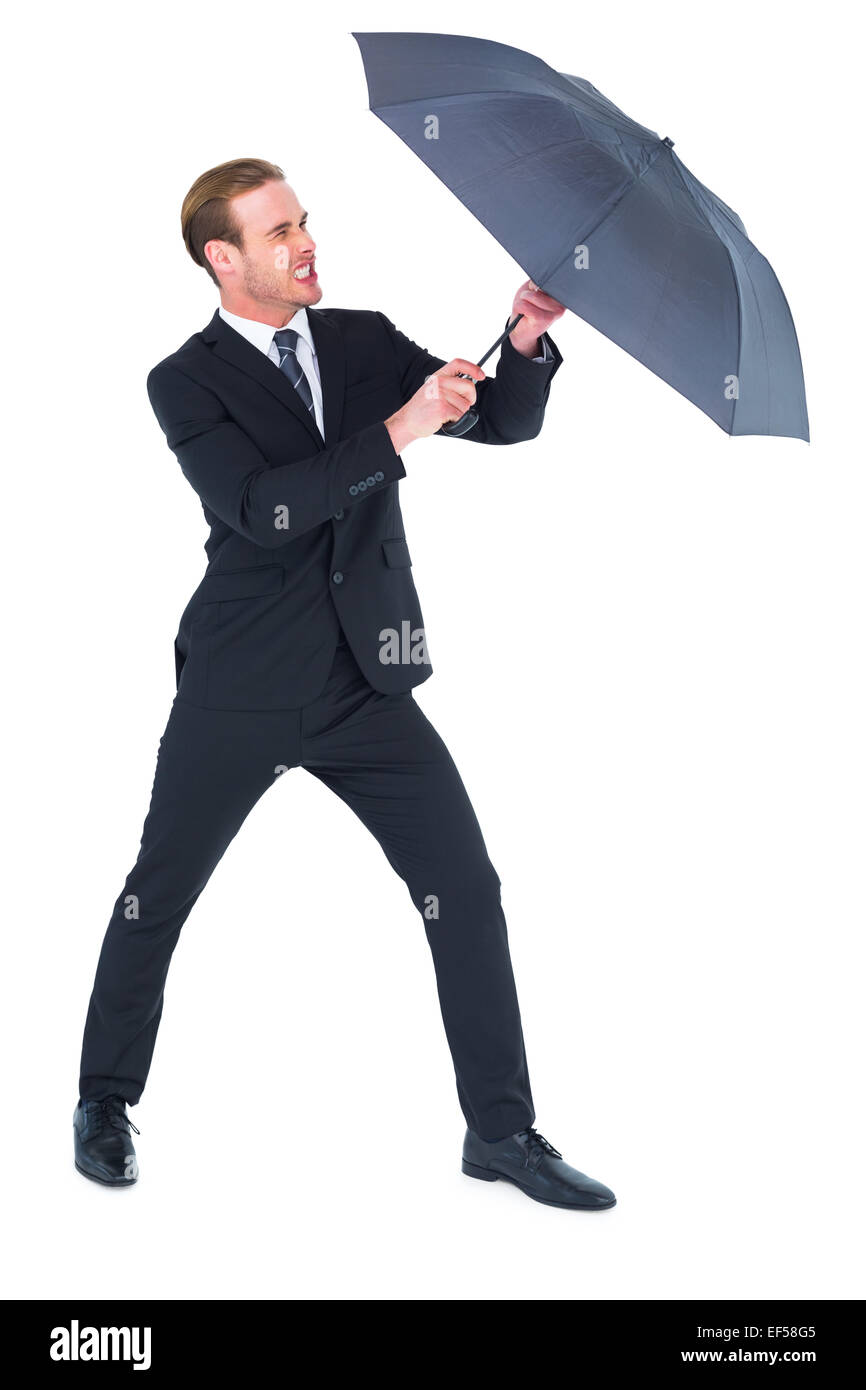 Businessman holding umbrella to protect himself Stock Photo - Alamy